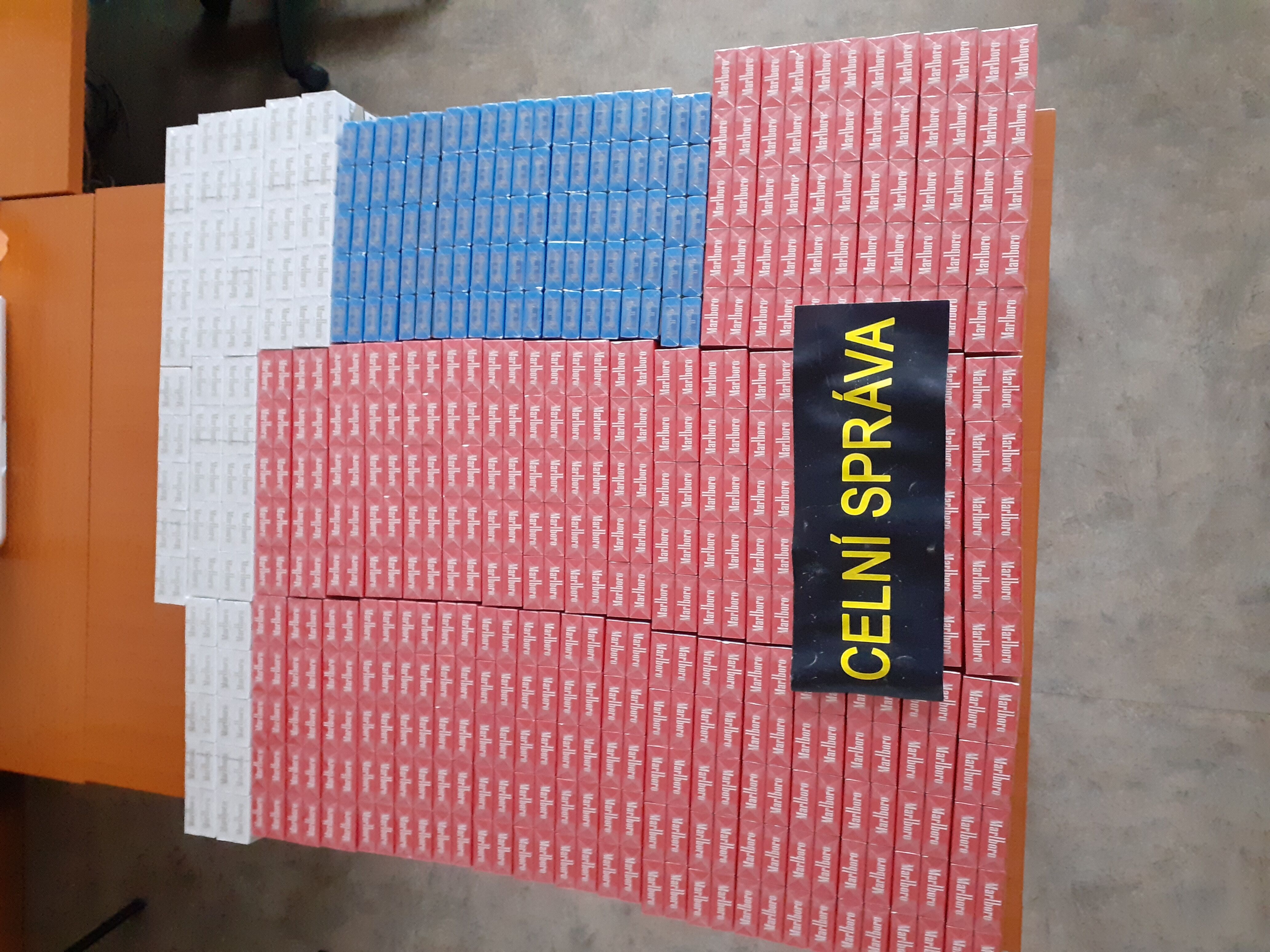 Červený cestovní kufr ukrýval 12 tisíc nelegálních cigaret