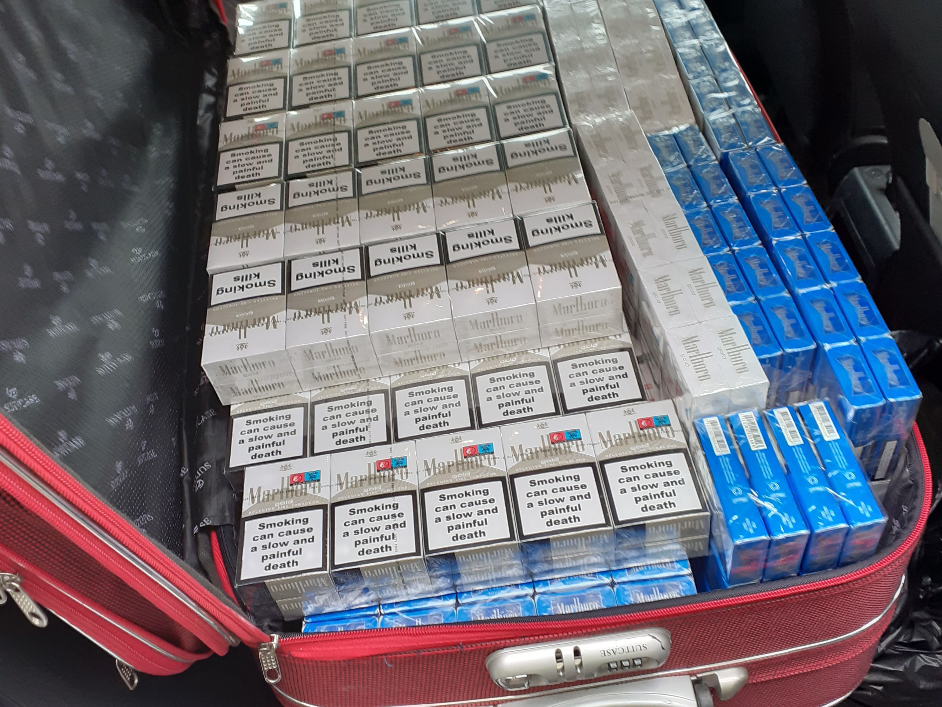 Červený cestovní kufr ukrýval 12 tisíc nelegálních cigaret